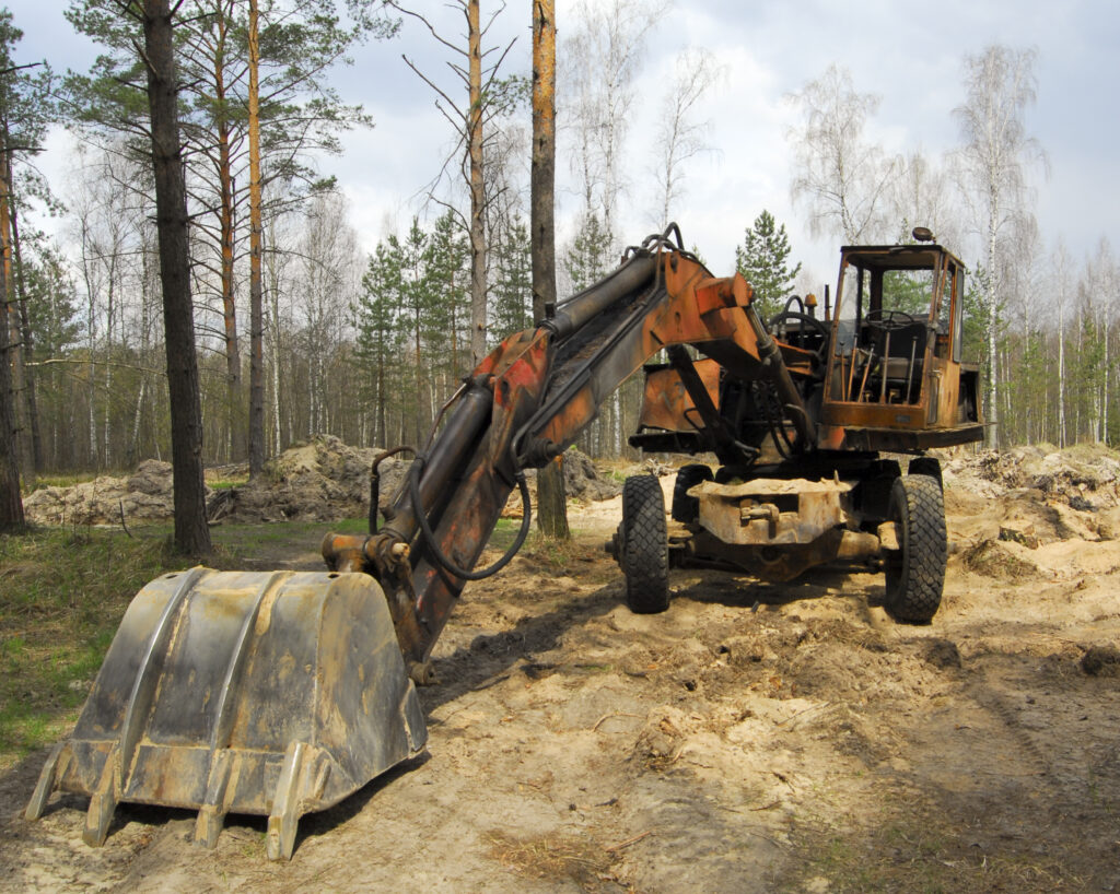 Old wheeled excavator in forest clearing