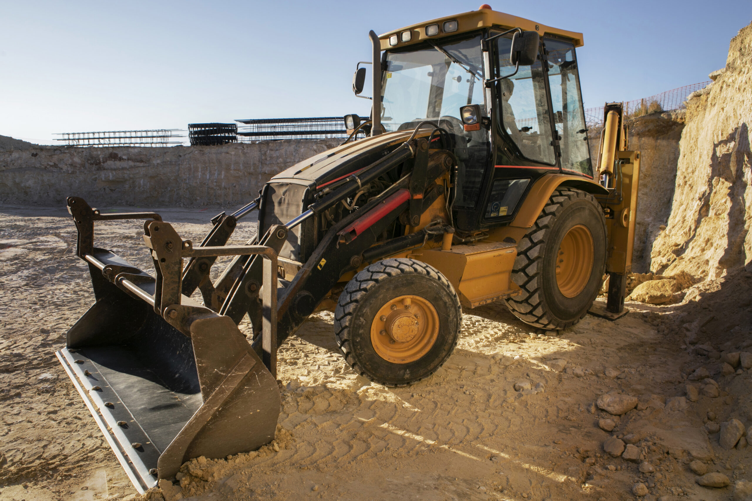 Backhoe loader at sandy construction site